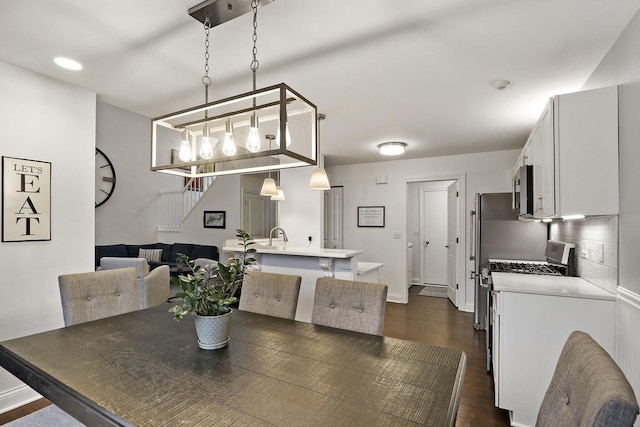 dining area with stairway, dark wood-style flooring, and baseboards