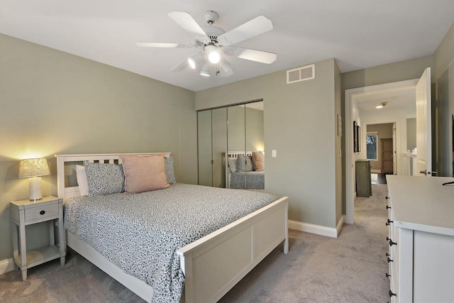 bedroom featuring light carpet, baseboards, visible vents, a ceiling fan, and a closet