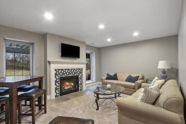 living area featuring baseboards, carpet flooring, a tiled fireplace, and recessed lighting