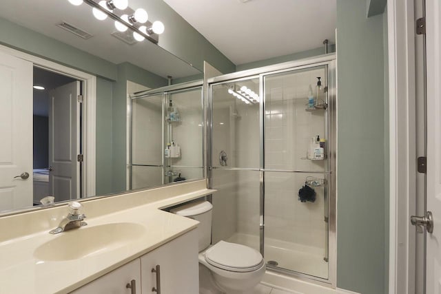 bathroom with toilet, a stall shower, vanity, and visible vents