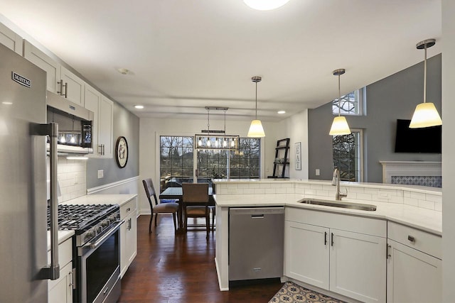 kitchen featuring appliances with stainless steel finishes, a wealth of natural light, light countertops, and a sink