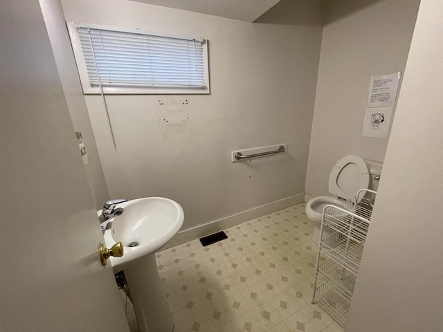 bathroom featuring tile patterned floors, toilet, and baseboards