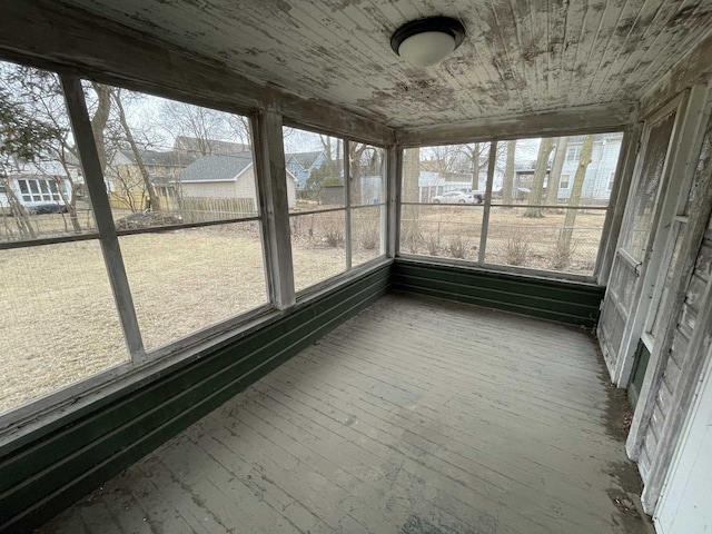 unfurnished sunroom featuring wood ceiling and a wealth of natural light