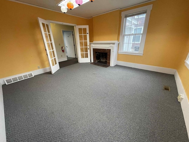 unfurnished living room with a fireplace with flush hearth, french doors, visible vents, and ornamental molding