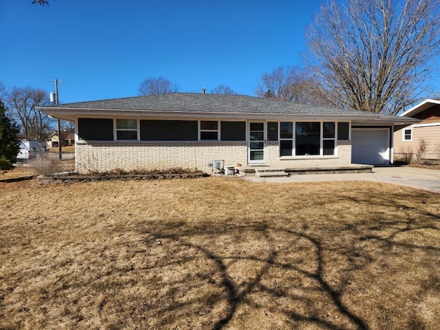 view of front of property with driveway, brick siding, a front lawn, and an attached garage