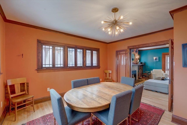 dining room featuring crown molding, light wood-style floors, and a notable chandelier