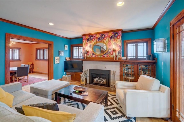 living room with baseboards, ornamental molding, a brick fireplace, and recessed lighting