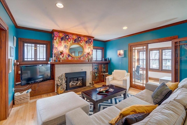 living area with crown molding, a fireplace, wood finished floors, and recessed lighting