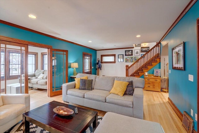 living area with baseboards, light wood-style flooring, ornamental molding, stairs, and recessed lighting