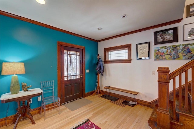 foyer entrance featuring light wood-style flooring, stairs, baseboards, and crown molding