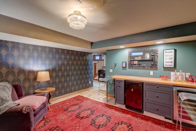 interior space featuring a dry bar, wallpapered walls, beverage cooler, baseboards, and fridge