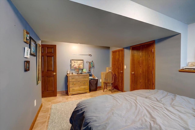 bedroom featuring baseboards and light tile patterned floors