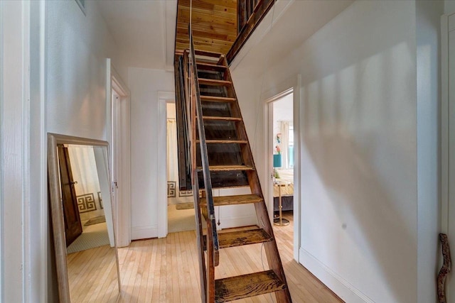 stairway with wood-type flooring and baseboards