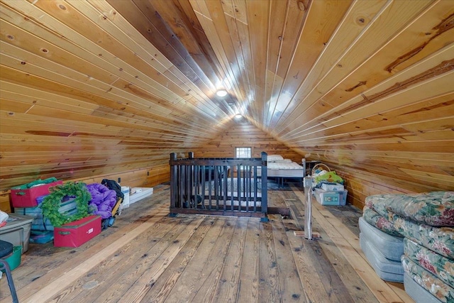 unfurnished bedroom featuring vaulted ceiling, wood walls, wooden ceiling, and hardwood / wood-style flooring