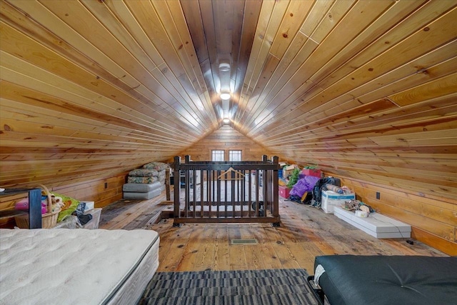 unfurnished bedroom with lofted ceiling, wood ceiling, wooden walls, and hardwood / wood-style flooring