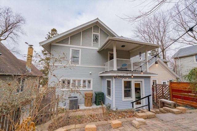 back of property featuring central AC unit, fence, and a balcony