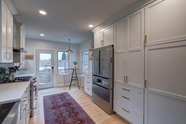 kitchen featuring stainless steel range, recessed lighting, freestanding refrigerator, light stone countertops, and light wood-type flooring