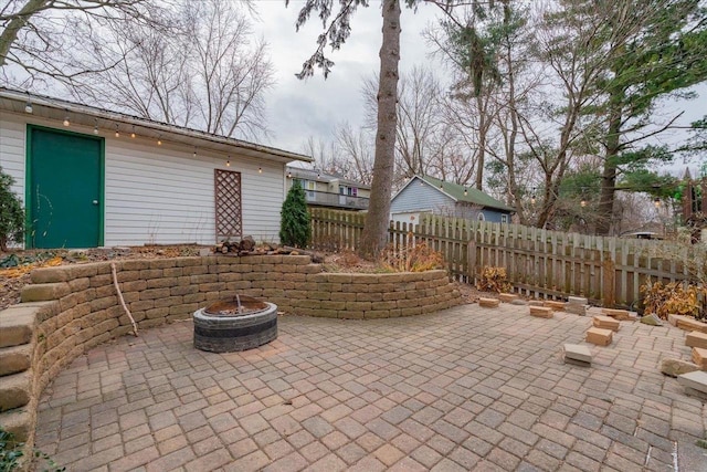 view of patio / terrace with an outdoor fire pit and fence