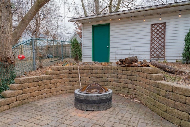 view of outdoor structure featuring an outdoor fire pit, fence, and an outdoor structure