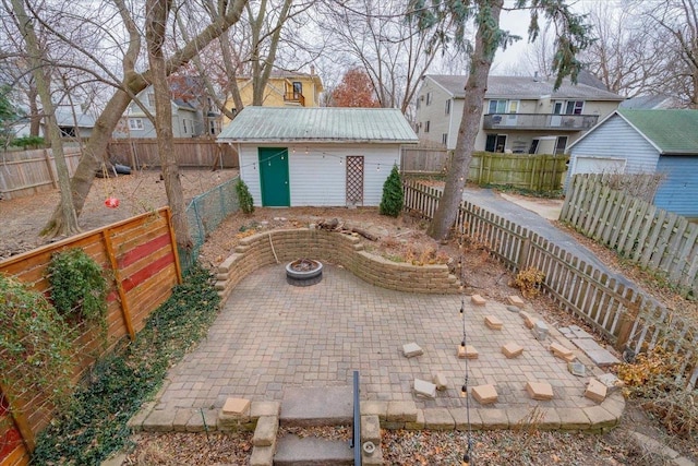 view of patio with an outbuilding, a fenced backyard, a fire pit, a storage shed, and a residential view