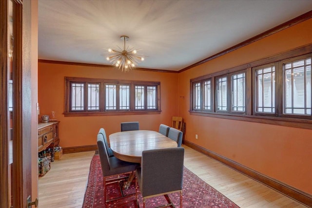 dining room with light wood-style flooring, ornamental molding, and baseboards