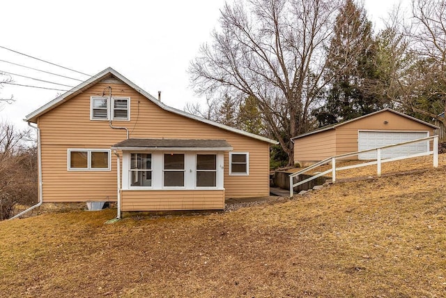 back of property featuring an outdoor structure and a detached garage