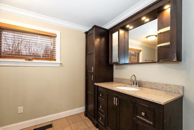 bathroom featuring vanity, baseboards, visible vents, tile patterned floors, and crown molding