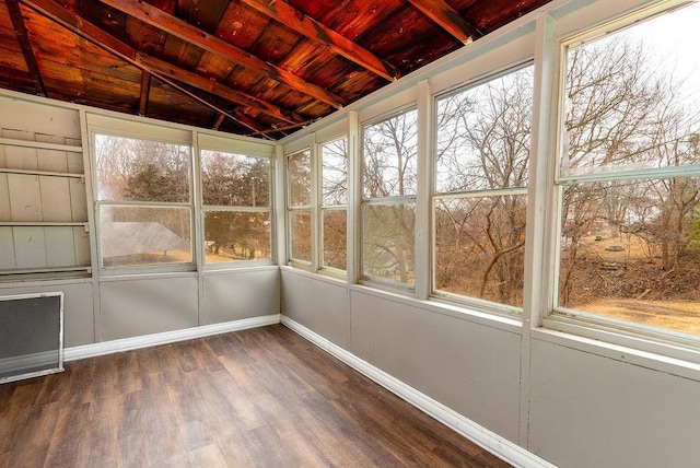 unfurnished sunroom featuring vaulted ceiling with beams, plenty of natural light, and wood ceiling