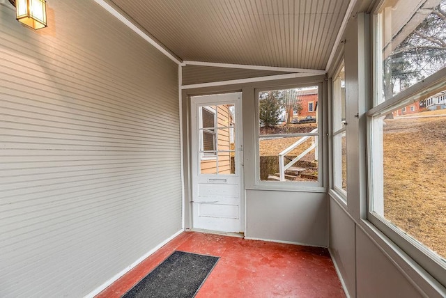 unfurnished sunroom featuring vaulted ceiling