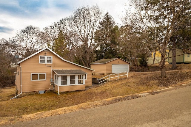 view of front of property with a garage and an outbuilding