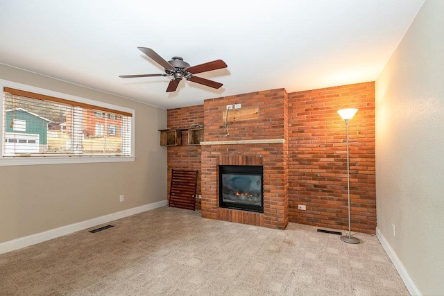 unfurnished living room featuring a brick fireplace, visible vents, baseboards, and carpet flooring