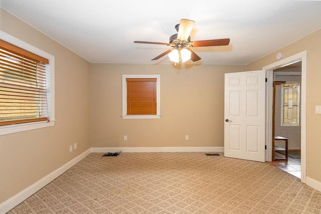 unfurnished bedroom with light colored carpet, ceiling fan, visible vents, and baseboards