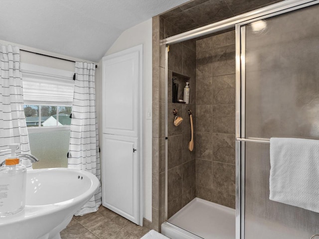 bathroom featuring lofted ceiling, a stall shower, a textured ceiling, and tile patterned floors