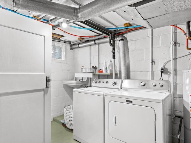 laundry room with laundry area, water heater, and washing machine and clothes dryer