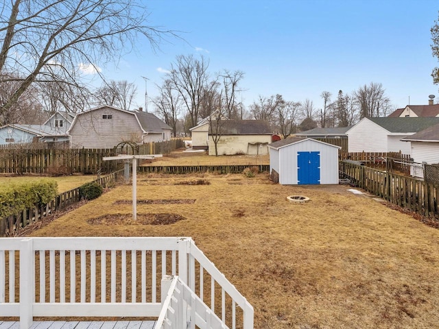 view of yard with an outbuilding, a fenced backyard, a residential view, and a storage shed