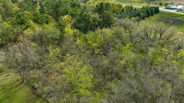 drone / aerial view featuring a wooded view