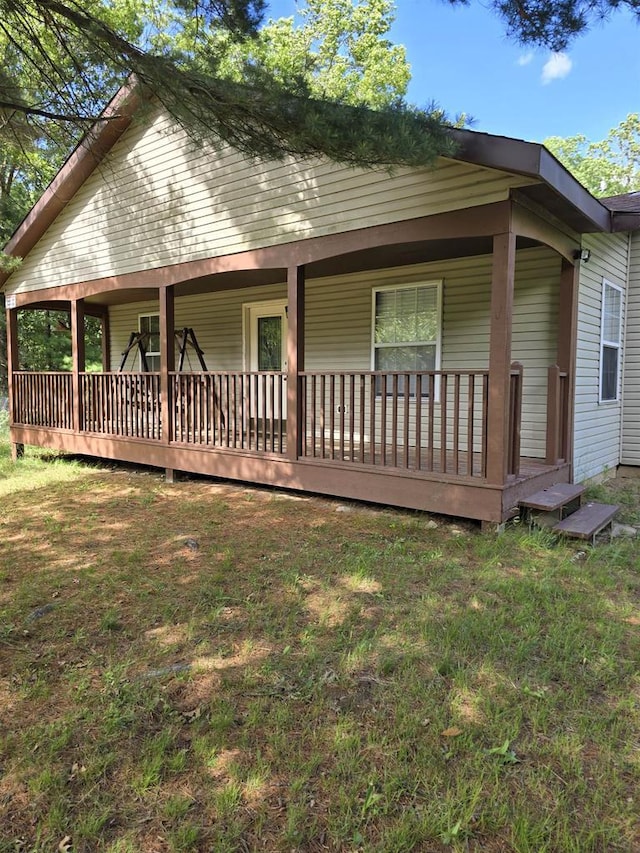 exterior space with covered porch and a front lawn