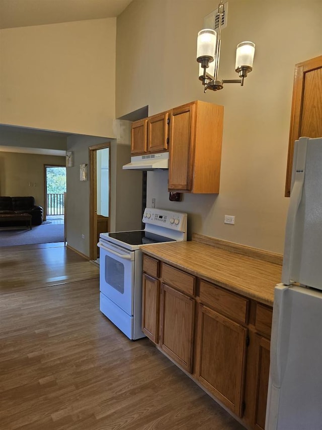 2838 W 3rd Dr, Oxford, WI 53952 - kitchen featuring white appliances, under cabinet range hood, high vaulted ceiling, dark wood-style flooring, and brown cabinetry