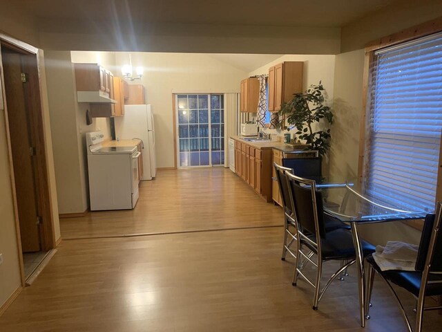 2838 W 3rd Dr, Oxford, WI 53952 - kitchen featuring stove, light wood-style floors, a sink, under cabinet range hood, and lofted ceiling