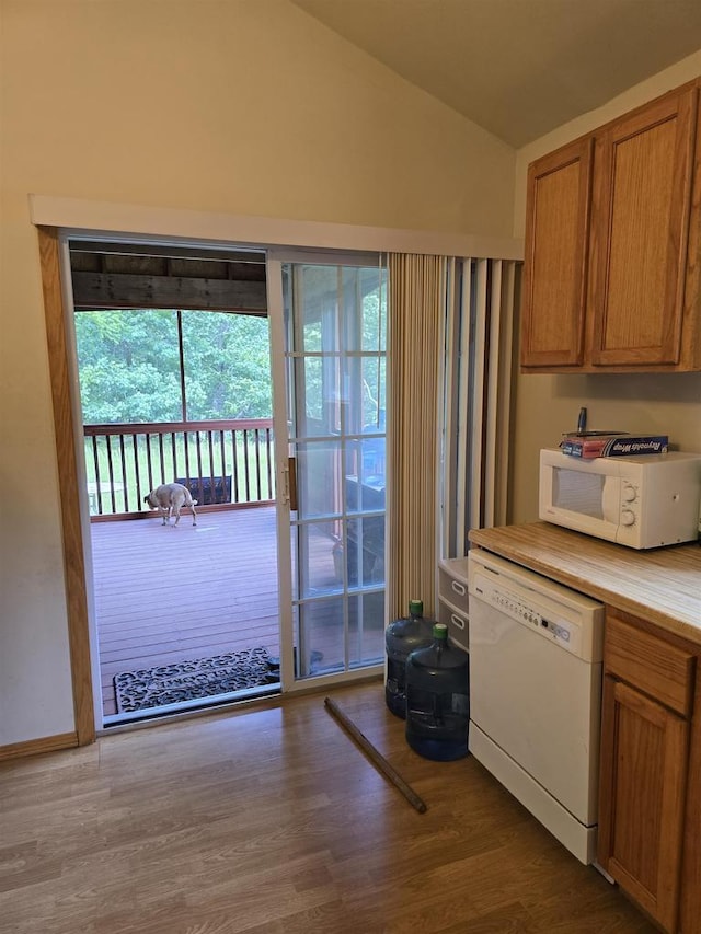 2838 W 3rd Dr, Oxford, WI 53952 - kitchen with white appliances, lofted ceiling, wood finished floors, brown cabinetry, and light countertops