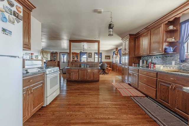 kitchen with a wainscoted wall, white appliances, a sink, open shelves, and dark wood finished floors