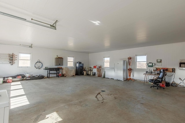 garage featuring freestanding refrigerator and heating unit