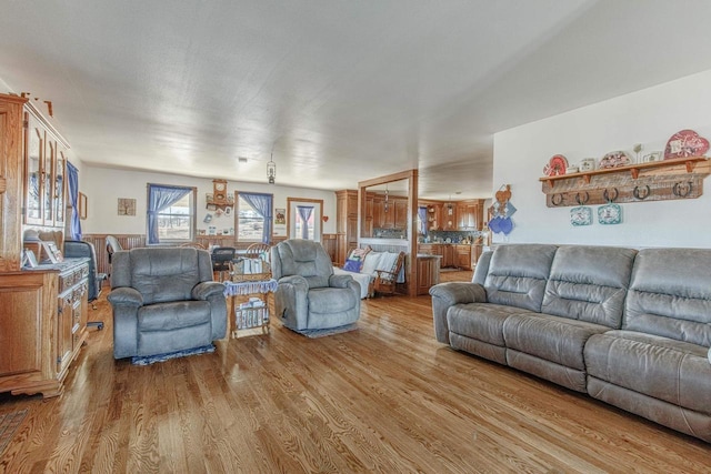 living room featuring a wainscoted wall and light wood finished floors