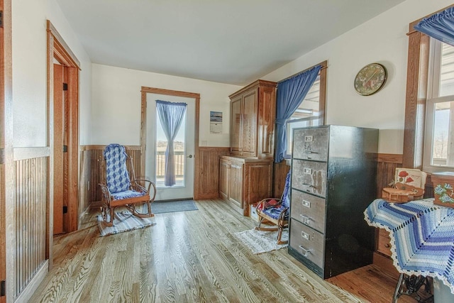 sitting room featuring light wood finished floors and wainscoting