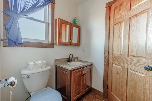 bathroom with vanity, toilet, and wood finished floors