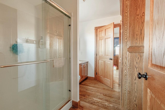 bathroom with a shower stall, vanity, and wood finished floors