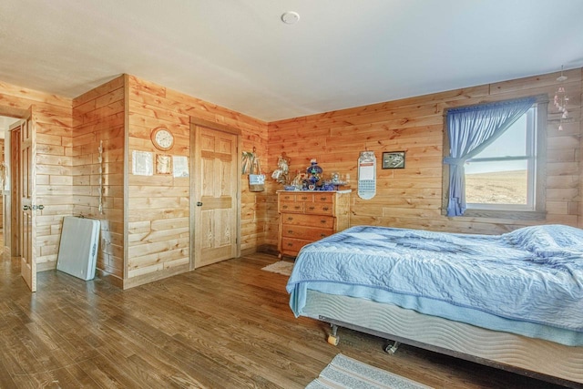 bedroom featuring wood walls and wood finished floors