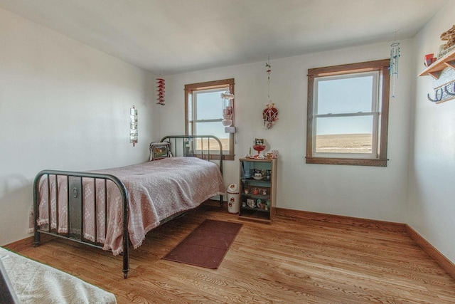 bedroom featuring wood finished floors and baseboards