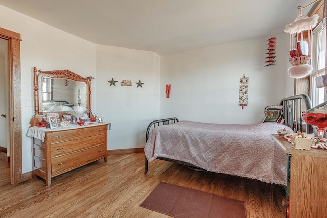 bedroom featuring baseboards and wood finished floors