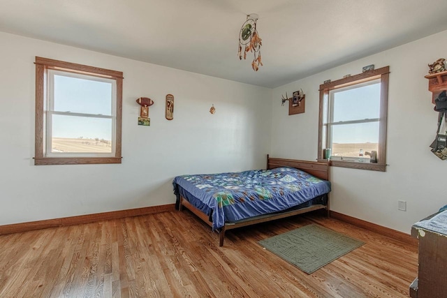 bedroom with baseboards and wood finished floors